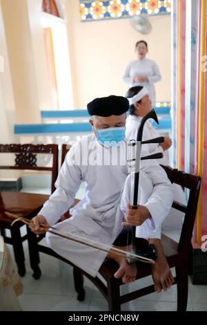 Ein vietnamesischer Mann, der einen Dan Nhi (Dan Co) spielt, ein Musikinstrument mit zwei Saiten. Cao Dai Tempel. Tan Chau. Vietnam. Stockfoto