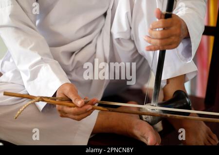 Ein vietnamesischer Mann, der einen Dan Nhi (Dan Co) spielt, ein Musikinstrument mit zwei Saiten. Cao Dai Tempel. Tan Chau. Vietnam. Stockfoto