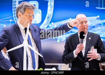 Hannover, Deutschland. 18. April 2023. Robert Habeck (Bündnis 90/die Grünen, l), Bundesminister für Wirtschaft und Klimaschutz, steht vor einem Modell einer Windturbine während einer Führung durch den Stand von Phoenix Contact auf der Hannover Messe. Neben ihm steht Frank Stührenberg (r), CEO Phoenix Contact. Vom 17. Bis 21. April 2023 findet die weltweit größte Industriemesse statt. Kredit: Michael Matthey/dpa/Alamy Live News Stockfoto