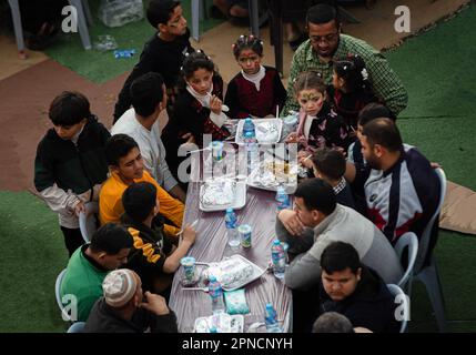 Gaza, Palästina. 17. April 2023. Palästinensische Familien essen während des heiligen Monats Ramadan mit ihren Nachbarn, Freunden und Verwandten in Khan Yunis im südlichen Gazastreifen ein gemeinsames Iftar-Essen. (Foto: Yousef Masoud/SOPA Images/Sipa USA) Guthaben: SIPA USA/Alamy Live News Stockfoto