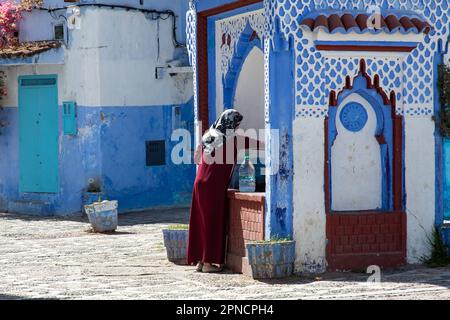 Chefchaouen, Marokko 2022: Die Menschen gehen durch die einzigartigen engen und farbigen Straßen der blau getünchten Stadt Chefchaouen. Beliebte Touristenattraktion Stockfoto