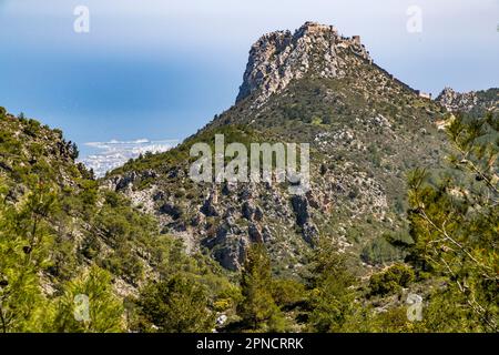 Blick auf die hohe Burg von St. Hilarion, 700 Meter hoch, erbaut auf zerklüfteten Felsen. Im Hintergrund die Hafenstadt Girne/Kyrenia. Agirda, Zypern Stockfoto