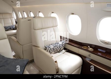 Bequeme Stühle in einem modernen Business-Jet-Flugzeug Stockfoto