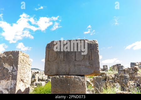 Stein mit einer Inschrift in lateinischer Schrift in der antiken Stadt Cuicul-Djemila. UNESCO-Weltkulturerbe. Stockfoto