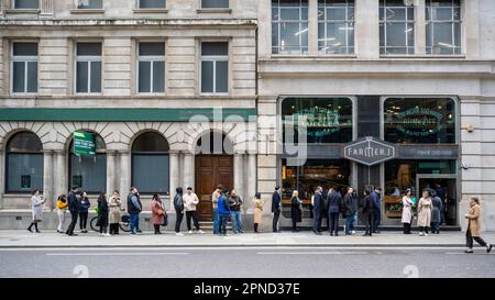 London, Großbritannien. 18. April 2023 Stadtarbeiter stehen in der City of London für ein Mittagessen in der Schlange. Das Amt für nationale Statistik (ONS) hat berichtet, dass die Durchschnittseinkommen ohne Boni in den drei Monaten bis Februar im Vergleich zum Vorjahr um 6,6 % gestiegen sind. Ökonomen haben angemerkt, dass die Bank of England die Zinssätze von derzeit 4,25% erhöhen könnte, wenn ihr geldpolitischer Ausschuss am 11. Mai zur Bekämpfung der Inflation zusammentritt. Kredit: Stephen Chung / Alamy Live News Stockfoto