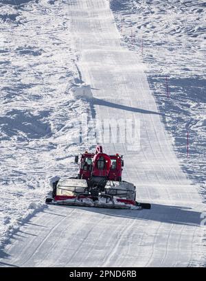 Huez, Frankreich - 9. April 2023: Schneekatze, Ratsche PistenBully - Maschine zur Schneevorbereitung bei der Arbeit in Alpe D'huez Stockfoto