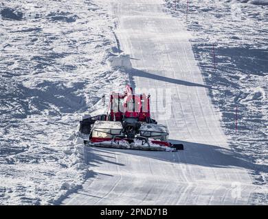 Huez, Frankreich - 9. April 2023: Schneekatze, Ratsche PistenBully - Maschine zur Schneevorbereitung bei der Arbeit in Alpe D'huez Stockfoto