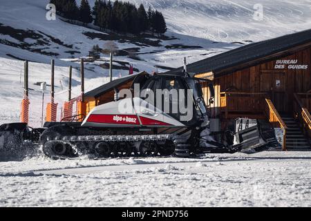 Huez, Frankreich - 9. April 2023: Schneekatze, Ratsche PistenBully - Maschine zur Schneevorbereitung bei der Arbeit in Alpe D'huez Stockfoto