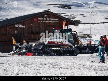 Huez, Frankreich - 9. April 2023: Schneekatze, Ratsche PistenBully - Maschine zur Schneevorbereitung bei der Arbeit in Alpe D'huez Stockfoto