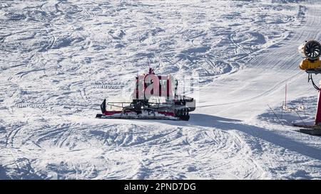 Huez, Frankreich - 9. April 2023: Schneekatze, Ratsche PistenBully - Maschine zur Schneevorbereitung bei der Arbeit in Alpe D'huez Stockfoto