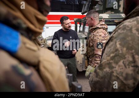 Avdiivka, Ukraine. 18. April 2023. Der ukrainische Präsident Wolodymyr Zelenskyy, Left, unterhält sich mit einem ukrainischen Soldaten vor dem Evakuierungsbus von Scania für verwundete Soldaten und Zivilisten während eines Besuchs an den Frontlinien in der Region Donezk am 18. April 2023 in Avdiivka, Ukraine. Kredit: Pool Photo/Pressestelle Des Ukrainischen Präsidenten/Alamy Live News Stockfoto