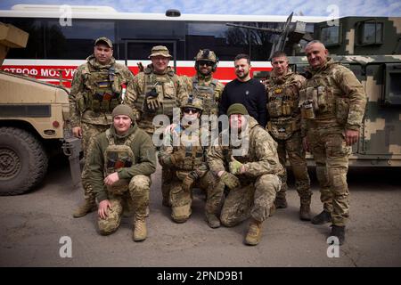 Avdiivka, Ukraine. 18. April 2023. Der ukrainische Präsident Wolodymyr Zelenskyy, Zentrum, posiert mit einem ukrainischen Soldaten vor dem Evakuierungsbus Scania für verwundete Soldaten und Zivilisten während eines Besuchs an den Frontlinien in der Donezk-Region am 18. April 2023 in Avdiivka, Ukraine. Kredit: Pool Photo/Pressestelle Des Ukrainischen Präsidenten/Alamy Live News Stockfoto