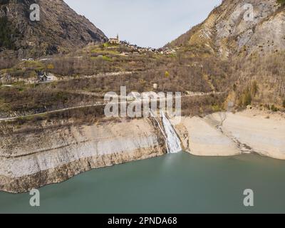 Panoramaaufnahme der Drohne vom Wasserfall, der in den Lac Chambon und das Dorf Mizoën in den französischen Alpen fließt Stockfoto