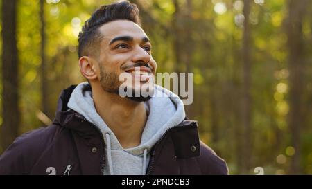 Männliches glückliches Gesicht Porträt eines jungen muslimischen lächelnden hispanischen arabers, der draußen posiert und vor die Kamera schaut, selbstbewusster Mann, Forstingenieur steht Stockfoto
