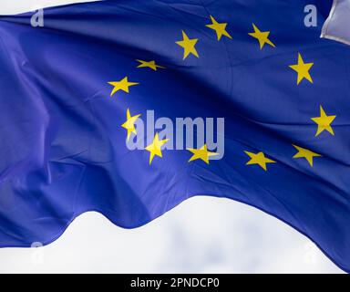 Offizielle Flagge der Europäischen Union vor blauem Himmel. Stockfoto