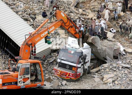 Torkham. 18. April 2023. Am 18. April 2023 entfernt ein Bagger Trümmer an einem Erdrutsch im nordwestlichen pakistanischen Torkham. Acht Menschen wurden verletzt und unzählige weitere verschwanden unter den Trümmern, nachdem am Dienstag an der Torkham-Grenze in Pakistans nordwestlicher Provinz Khyber Pakhtunkhwa Land gerutscht war, sagten Rettungsquellen. Kredit: Saeed Ahmad/Xinhua/Alamy Live News Stockfoto