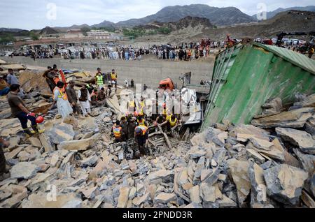 Torkham. 18. April 2023. Retter suchen am 18. April 2023 an einem Erdrutschplatz in Torkham im Nordwesten Pakistans nach Opfern. Acht Menschen wurden verletzt und unzählige weitere verschwanden unter den Trümmern, nachdem am Dienstag an der Torkham-Grenze in Pakistans nordwestlicher Provinz Khyber Pakhtunkhwa Land gerutscht war, sagten Rettungsquellen. Kredit: Str/Xinhua/Alamy Live News Stockfoto