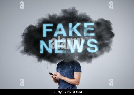 Eine dunkle Wolke, die mit "FAKE NEWS" beschriftet ist und über dem Kopf einer Person schwebt Stockfoto