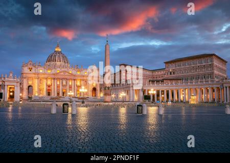 Vatikanstadt, Rom, Italien. Stadtbild des beleuchteten Petersdoms und des St. Petersplatz, Vatikanstadt, Rom, Italien bei Sonnenaufgang. Stockfoto