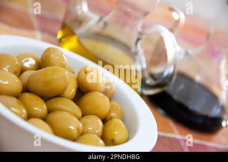 Grüne Oliven, mariniert mit Olivenöl und Balsamico-Essig Stockfoto