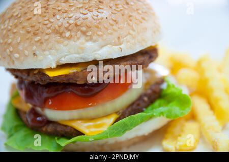 Doppelter Cheeseburger serviert mit Bratkartoffeln Stockfoto