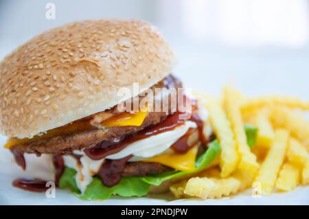 Doppelter Cheeseburger serviert mit Bratkartoffeln Stockfoto