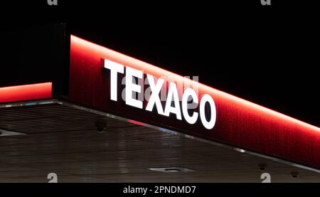 Das Texaco-Logo leuchtet nachts an der Tankstelle auf. Stockfoto