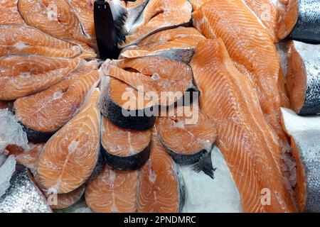 Viele frische, gekühlte Lachssteaks liegen auf dem Eis und werden im Sea Food Store aus nächster Nähe präsentiert Stockfoto