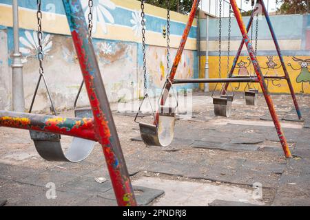 Heruntergekommene Schaukel auf dem Spielplatz alter Kinder Stockfoto