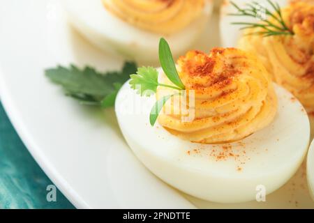 Gefüllte oder gefüllte Eier mit Paprika und Petersilie auf blauem Teller für ostertisch. Traditionelles Ostergericht. Gesunde Ernährung zum Frühstück. Top-Video Stockfoto