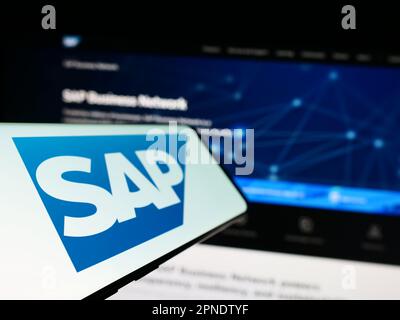 Mobiltelefon mit Logo des deutschen Softwareunternehmens SAP SE auf dem Bildschirm vor der Business-Website. Fokus auf der linken Seite des Telefondisplays. Stockfoto