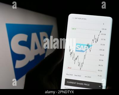 Person, die ein Smartphone mit der Website des deutschen Softwareunternehmens SAP SE auf dem Bildschirm vor dem Unternehmenslogo hält. Konzentrieren Sie sich auf die Mitte des Telefondisplays. Stockfoto