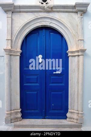 Griechenland. Tinos Island of Art, blaue Haustür mit Marmorbogen an der weißen Wand, kykladische Architektur im Dorf Pyrgos Stockfoto