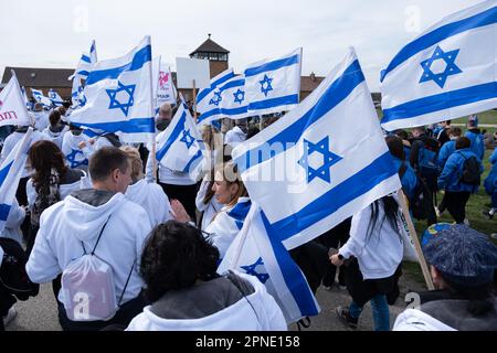 Czestochowa, Polen. 18. April 2023. Menschen mit israelischen Flaggen vor Birkenau, einem ehemaligen deutschen Konzentrations- und Vernichtungslager. Jedes Jahr kommen Tausende Juden nach Auschwitz-Birkenau, einem ehemaligen deutschen konzentrations- und Vernichtungslager, um am Internationalen Marsch der Lebenden teilzunehmen. Überlebende des Holocaust nehmen ebenfalls am marsch Teil. Kredit: SOPA Images Limited/Alamy Live News Stockfoto