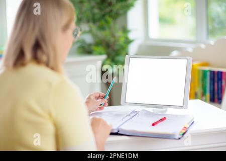 Online-Fernunterricht. Lehrer mit Computer führt Videokonferenz-Chat mit Schüler und Klassengruppe durch. Leerer Tablet-Bildschirm. Stockfoto