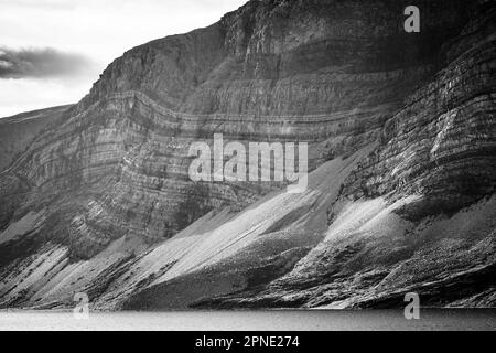 Sedimentschichten, sichtbar an der Seite der Berge entlang des Ufers von Saglek Fjord im Norden von Labrador, Kanada. Stockfoto