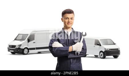 Junger Automechaniker, der einen Schraubenschlüssel vor Lieferwagen hält, isoliert auf weißem Hintergrund Stockfoto