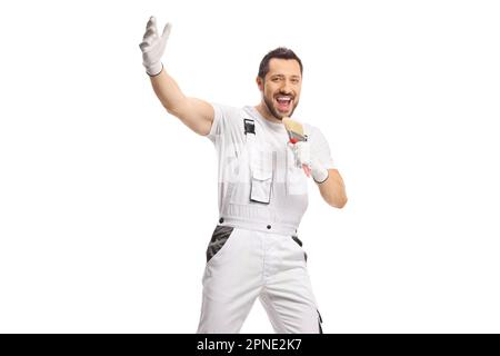 Glücklicher Maler in weißer Uniform, der isoliert auf weißem Hintergrund singt Stockfoto