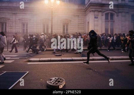 Jan Schmidt-Whitley/Le Pictorium - 17/4/2023 - Frankreich / Paris / Paris - La Police tente de contenir la foule en lancant des Granades lacrymogenes. Plusieurs milliers de personnes se sont reunies devant la mairie du 10e Arrondissement de Paris pour protester contre la Politique de Emmanuel Macron et contre la reforme des retraites. Plusieurs centaines de personnes ont ensuite parcouru Paris Pendant plusieurs heures en formant de multiples corteges sauvages et jouant au Chat et a la souris avec les Forces de l'ordre depassees par les evenements et la mobilite des groupes compose majoritaire Stockfoto