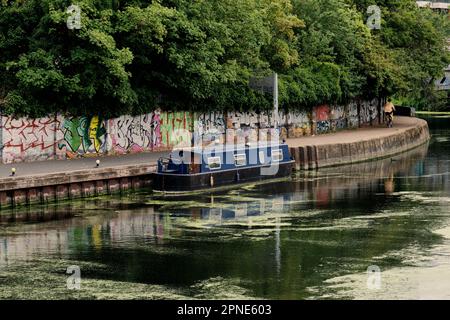 Ein Hausboot, das am Ufer eines Kanals im Osten Londons festgemacht ist. Eine urbane Szene abseits der üblichen Touristengegenden. London entdecken. Stockfoto