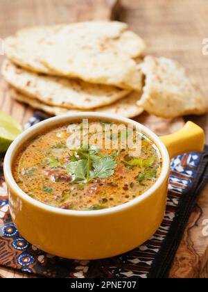 Currysuppe aus Mung Bean mit Naan-Brot. Zutaten: Gekeimte Mungbohnen, gemahlene Tomaten, Knoblauch, Ingwer, Kreuzkümmel, Koriander, Cayennepfeffer, Kokosnuss Stockfoto