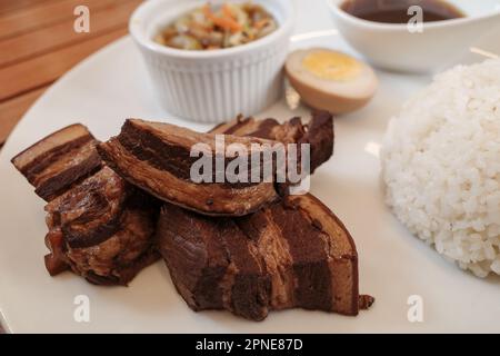 Nahaufnahme der Kakuni, Japanisch geschmorten Schweinebauch, mit Reis und Suppe auf weiße Platte. Stockfoto