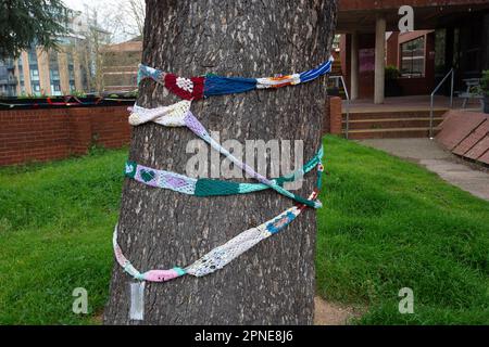 Maidenhead, Berkshire, Großbritannien. 18. April 2023. Bäume in der Nähe des Rathauses von Maidenhead haben Strickschals um sie herum. Die Einheimischen veranstalteten heute Abend eine Nachtwache vor dem Maidenhead Town Hall, um den Verlust von 200 Hektar Grünland im Maidenhead Golf Club zu betrauern. Das Land, das Teil des Wahlkreises der Abgeordneten Theresa May ist, wurde von Lord Grenville den Menschen von Maidenhead überlassen und sollte nicht erbaut werden. Allerdings plant Cala Homes, 1.800 Häuser an diesem Ort zu bauen, in denen Bäume und Lebensräume von Wildtieren zerstört werden. Obwohl es sich um Grünland handelt, wurde es in den lokalen Entwicklungsplan der Gemeinde aufgenommen. Kredit: Maureen M. Stockfoto