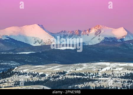 Erstes Sonnenaufgang über den Gipfeln der Flint Creek Range im Winter bei Garrison, montana Stockfoto