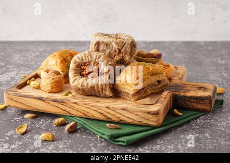 Holzbrett mit leckerem Baklava auf dem Tisch Stockfoto