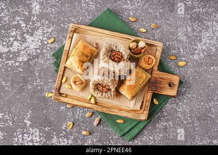 Holzbrett mit leckeren Baklava auf grunge Hintergrund Stockfoto