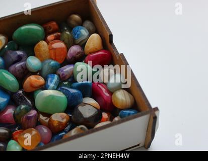 Weißes Holzetui mit rohen, bunten Edelsteinen in einem detaillierten Blickwinkel Stockfoto