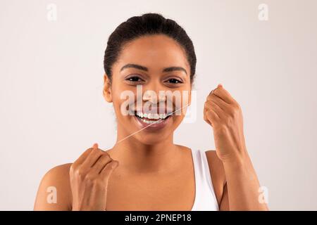 Frohes afroamerikanisches weibliches Zahnseide-Modell Stockfoto