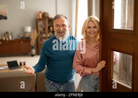 Joyful Mature Ehepaar Öffnet Die Tür Des Neuen Hauses, Das Drinnen Steht Stockfoto