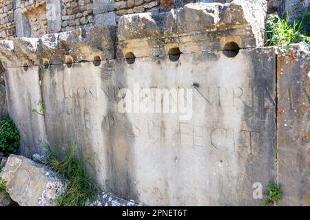 Stein mit einer Inschrift in lateinischer Schrift in der antiken Stadt Cuicul-Djemila. UNESCO-Weltkulturerbe. Stockfoto